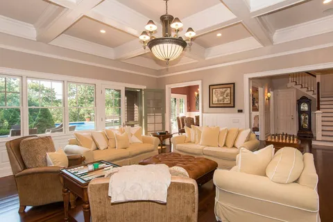 a living room with furniture a chandelier and a large window