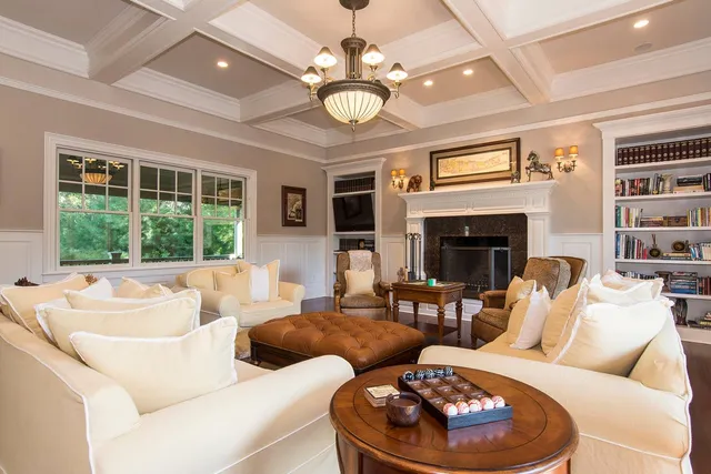 a living room with furniture a fireplace and a chandelier