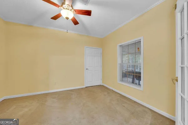 a bedroom with a bed and a flat tv screen on the dresser