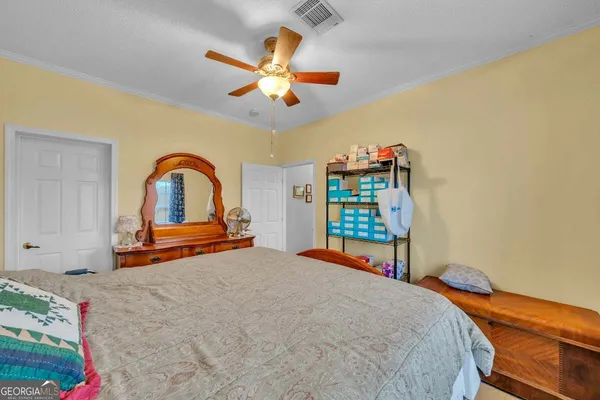 a bedroom with furniture and a air conditioner vent