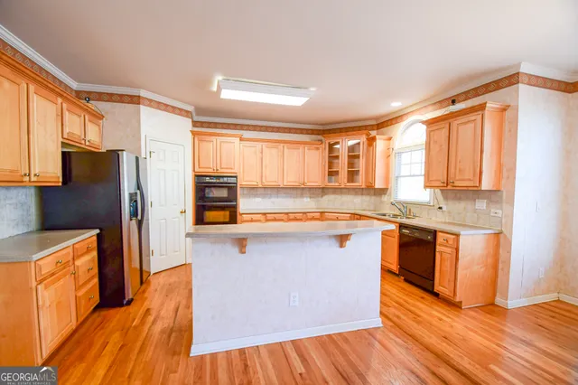 a kitchen with stainless steel appliances a refrigerator sink and wooden floor