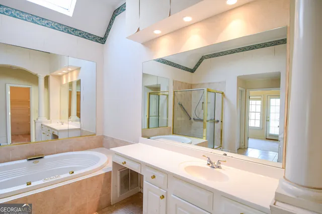 a bathroom with a tub sink and mirror