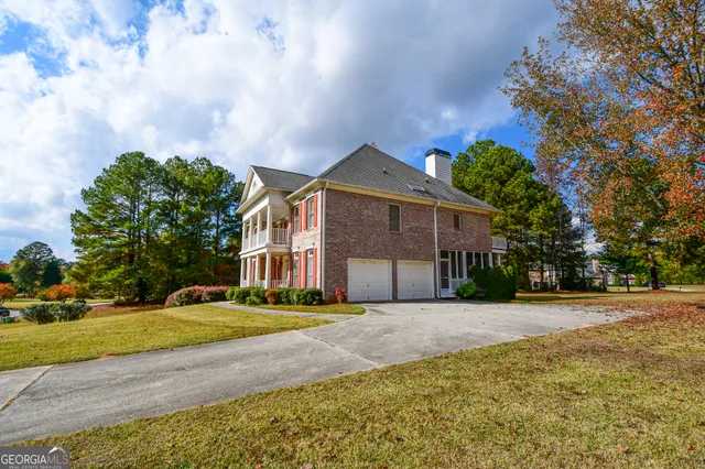 a front view of a house with a yard and trees