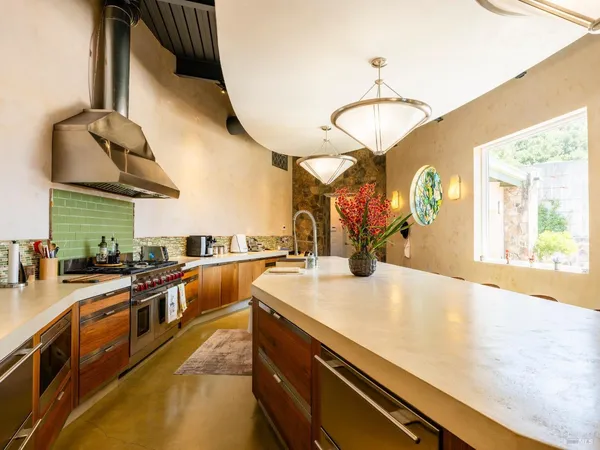 a kitchen with stainless steel appliances granite countertop a sink a stove and a wooden floors