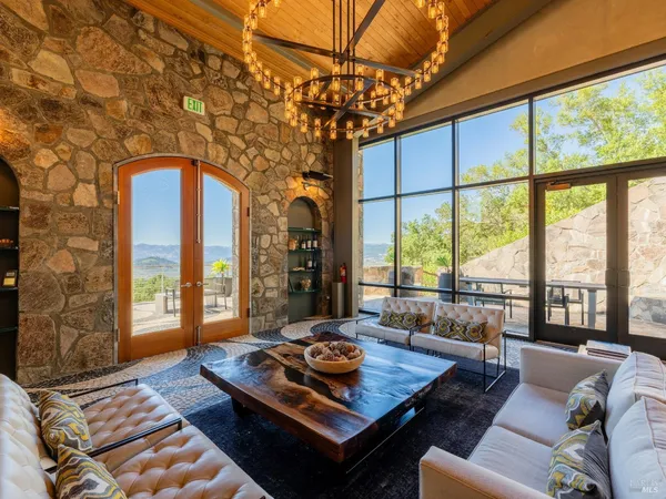 a living room with furniture and floor to ceiling windows