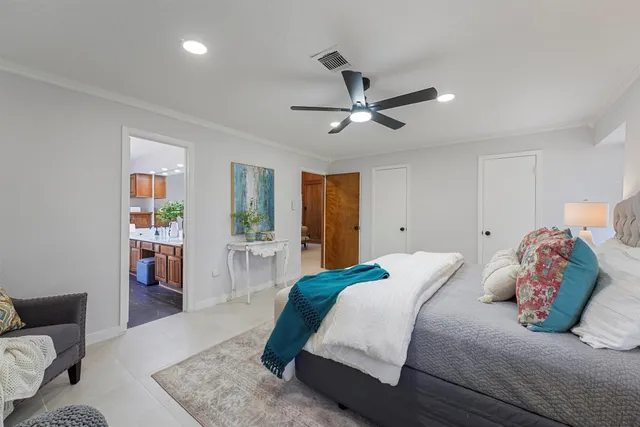 a bedroom with a large bed and a chandelier
