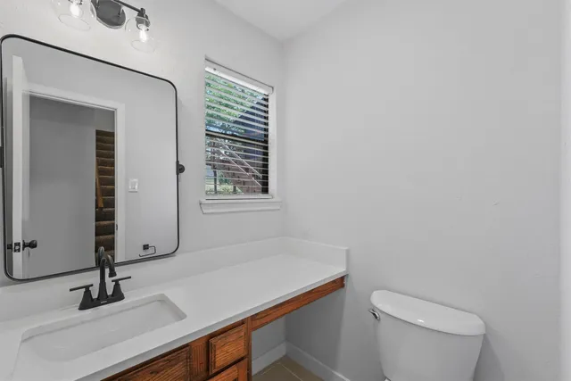 a bathroom with a sink a toilet and mirror