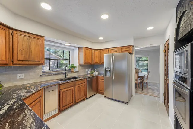 a kitchen with stainless steel appliances granite countertop a refrigerator and a sink