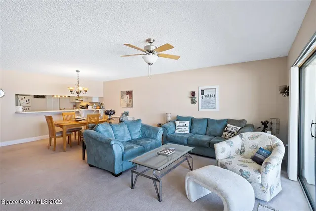 a living room with furniture a chandelier and a window