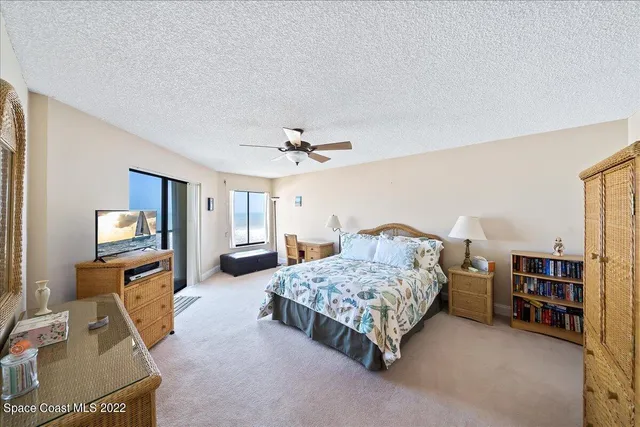 a bedroom with a bed furniture and a flat tv screen