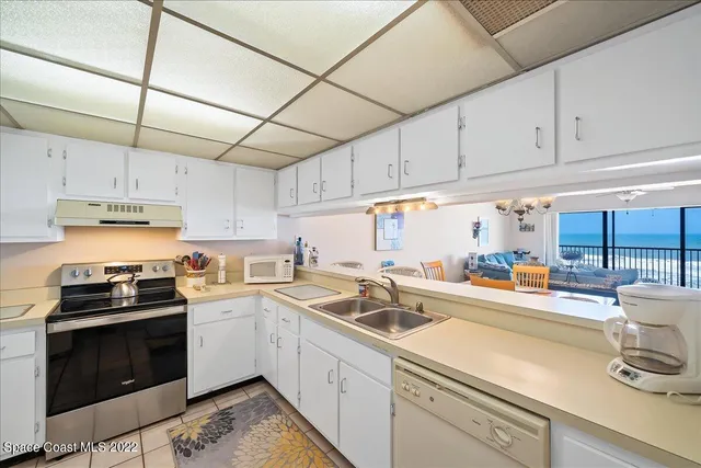 a kitchen with a sink a stove and cabinets