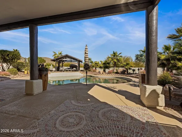 a swimming pool with barbeque oven table and chairs