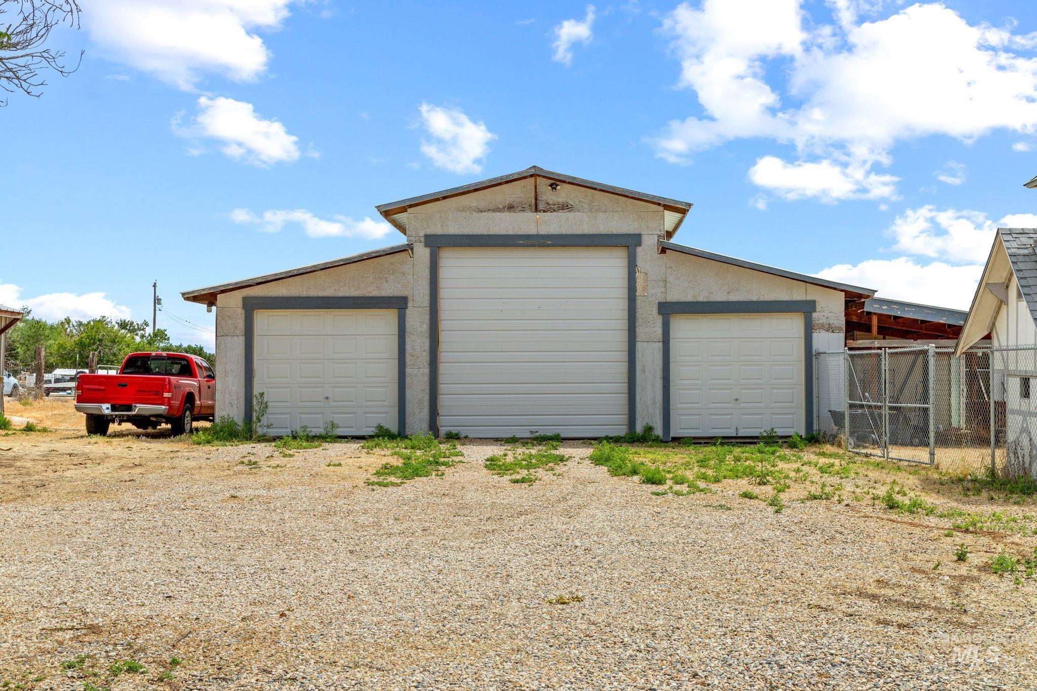 18338 Pride Lane Caldwell, ID 83607 - Photo 48 of 50 Detached outbuilding featuring three garage doors, a central oversized door, and two standard-sized doors