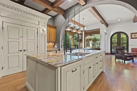 a kitchen with a stove and a wooden floor
