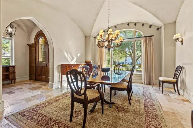 a dining room with furniture a chandelier and wooden floor