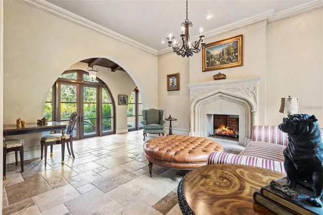 a living room with furniture a chandelier and a fireplace