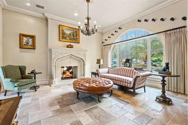 a living room with furniture a fireplace and a chandelier