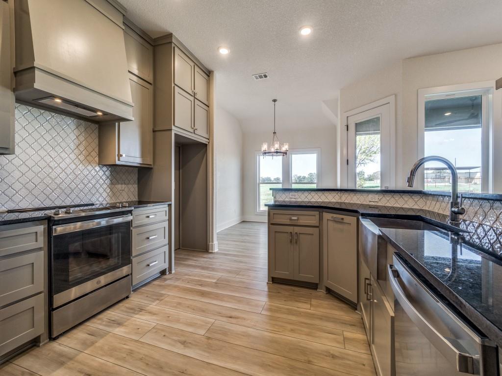 300 County Road 3141 Decatur, TX 76234 - Photo 11 of 25 a kitchen with stainless steel appliances granite countertop a stove a sink and a refrigerator
