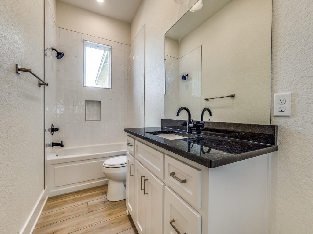 300 County Road 3141 Decatur, TX 76234 - Photo 17 of 25 a bathroom with a granite countertop sink a toilet a mirror and bathtub