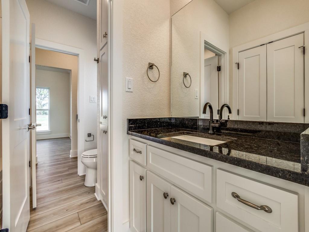 300 County Road 3141 Decatur, TX 76234 - Photo 19 of 25 a bathroom with a granite countertop sink and a mirror