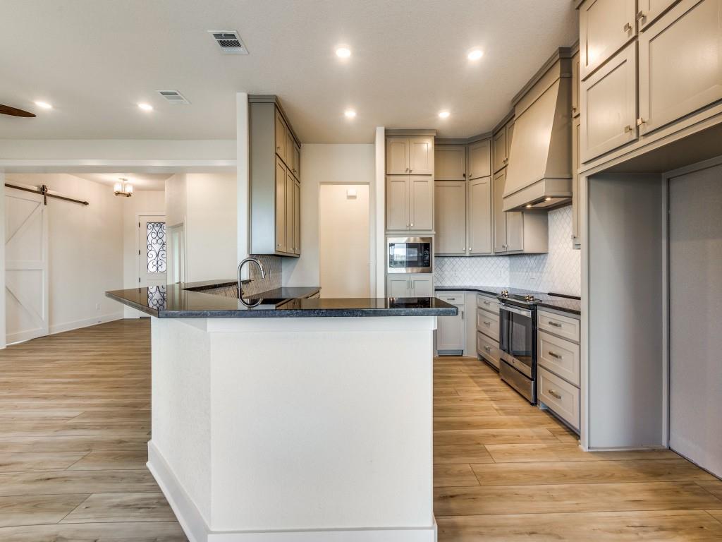 300 County Road 3141 Decatur, TX 76234 - Photo 9 of 25 a large kitchen with stainless steel appliances granite countertop a stove a sink and a refrigerator