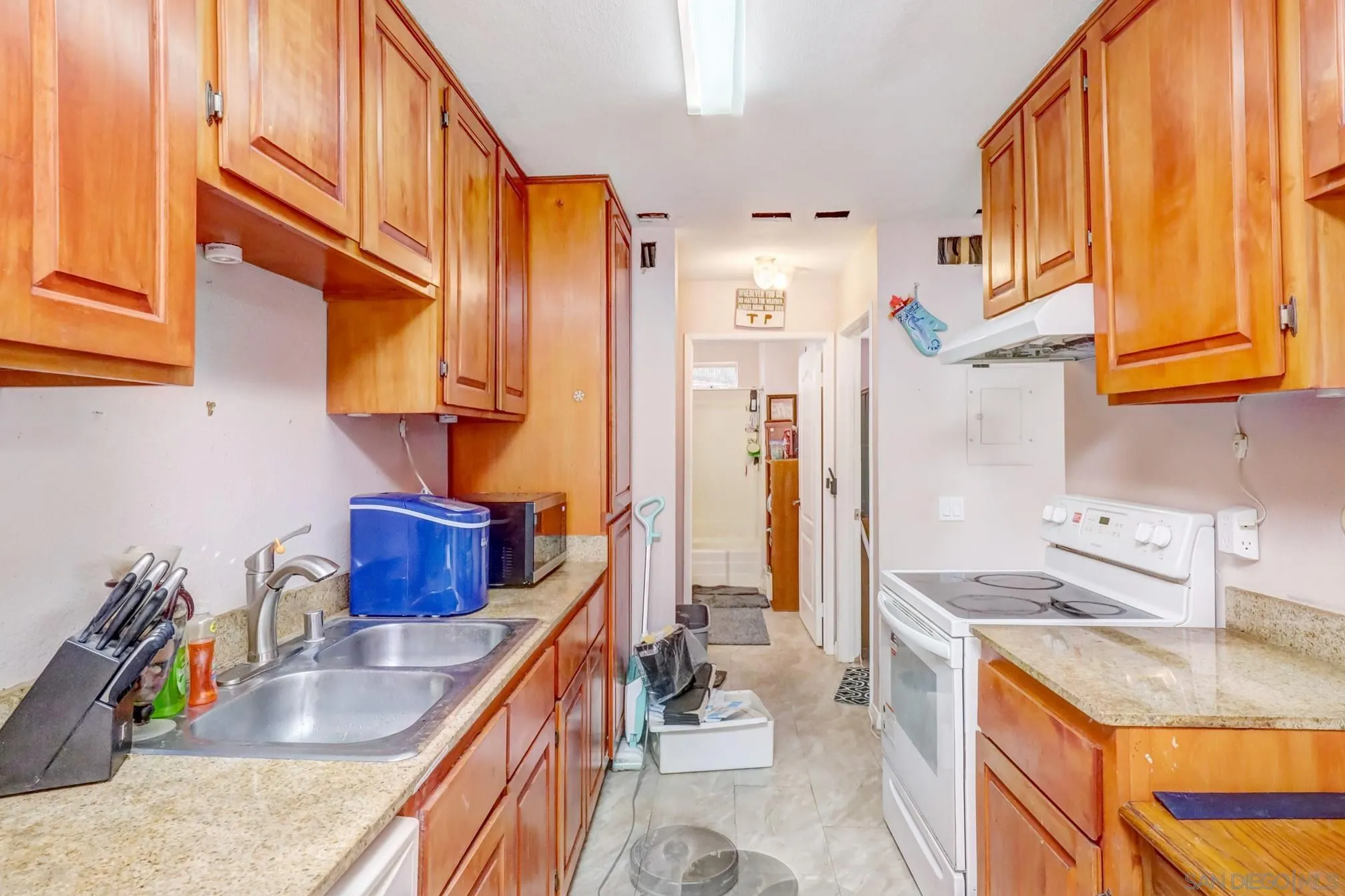 3557 Kenora Drive, Unit 17 Spring Valley, CA 91977 - Photo 4 of 8 a kitchen with stainless steel appliances granite countertop a sink a stove and a refrigerator