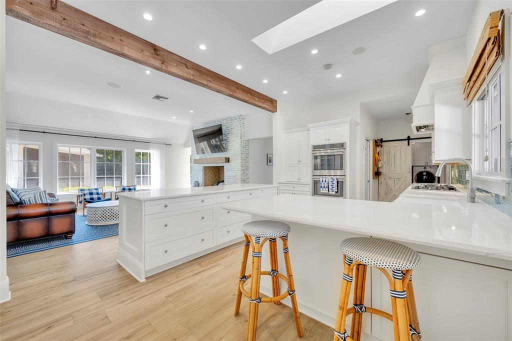 700 Pinetree Road Winter Park, FL 32789 - Photo 16 of 58 a large white kitchen with stainless steel appliances kitchen island granite countertop a large island in the center