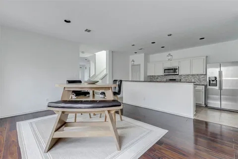 a living room with stainless steel appliances kitchen island a table chairs stove and refrigerator