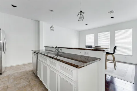a kitchen with granite countertop a sink stove and cabinets