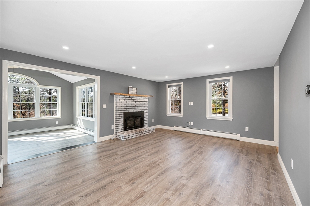 17 Autumn Street Windham, NH 03087 - Photo 15 of 42 an empty room with windows fireplace and wooden floor