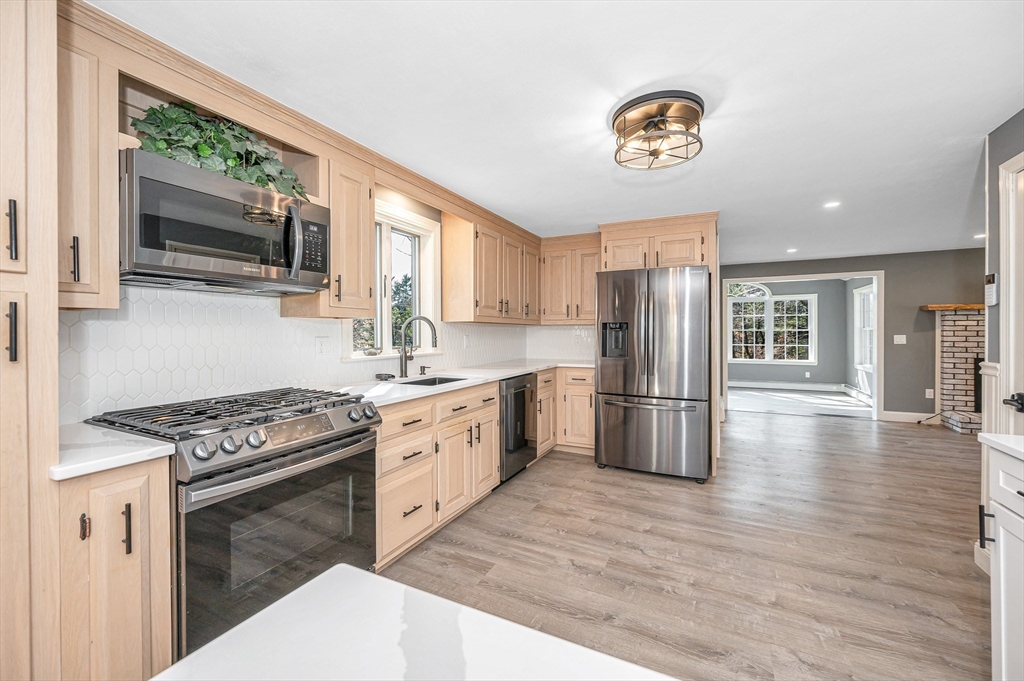 17 Autumn Street Windham, NH 03087 - Photo 10 of 42 a kitchen with stainless steel appliances granite countertop a stove a sink dishwasher and a refrigerator