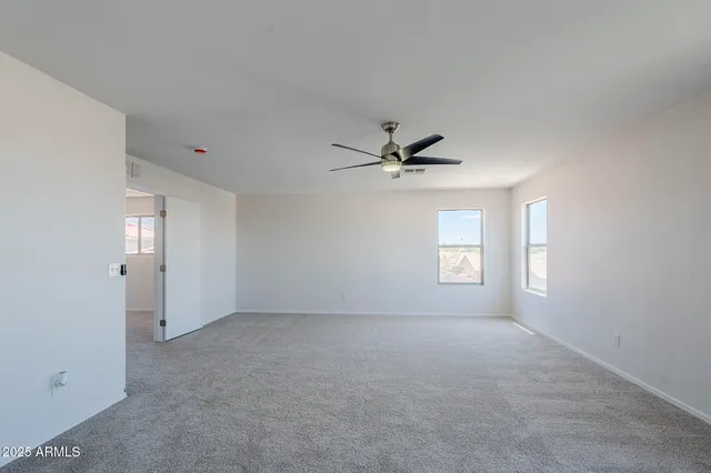 a view of empty room with window and ceiling fan