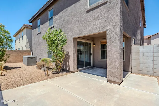a backyard of a house with table and chairs