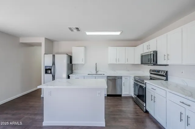 a kitchen with stainless steel appliances a sink stove refrigerator and cabinets