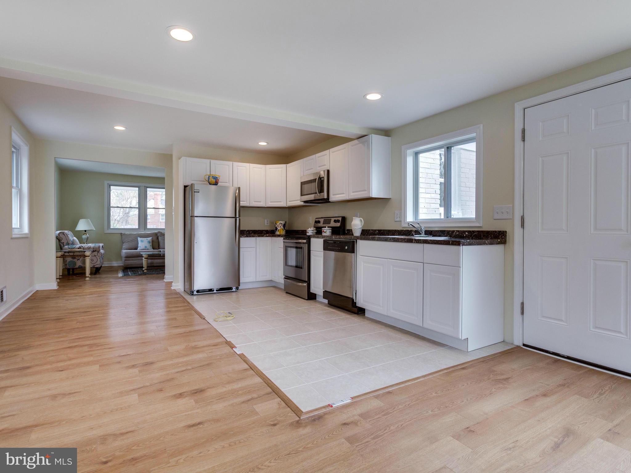 4002 Gannon Road Silver Spring, MD 20902 - Photo 8 of 30 a view of kitchen with stainless steel appliances granite countertop a stove top oven a sink dishwasher a refrigerator and white cabinets with wooden floor