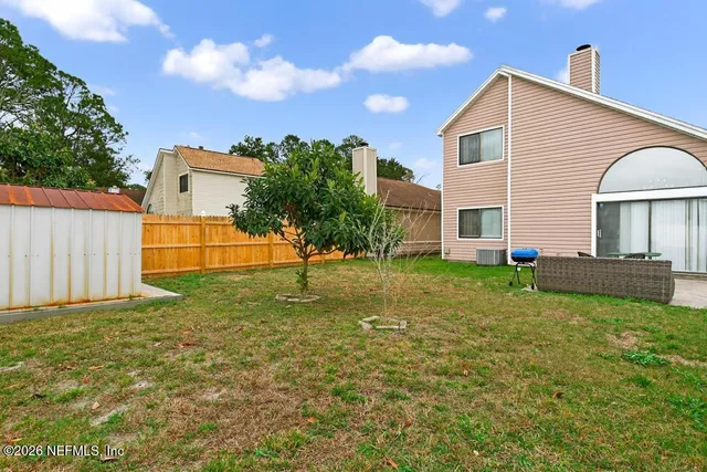 a view of a house with backyard and sitting area