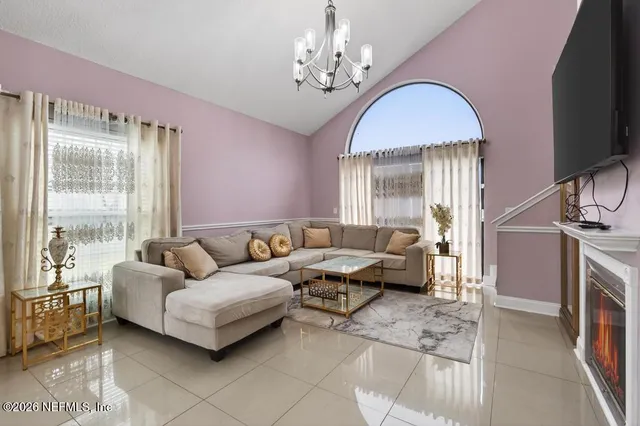 a living room with furniture a chandelier and a dining table