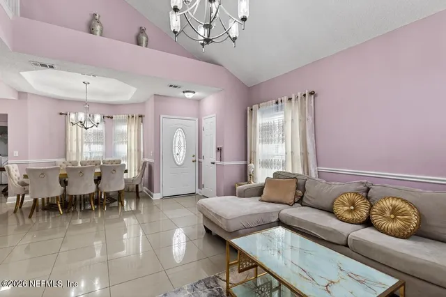 a view of a dining room with furniture and chandelier