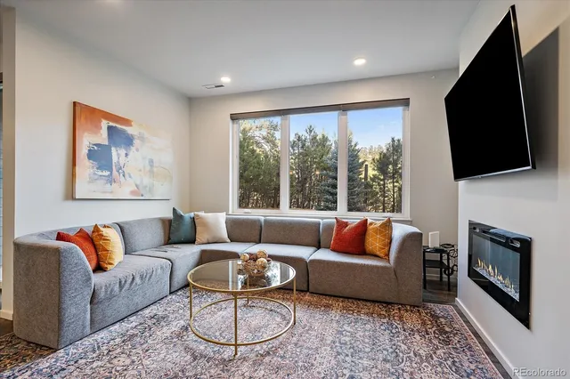 a living room with furniture a flat screen tv and a fireplace