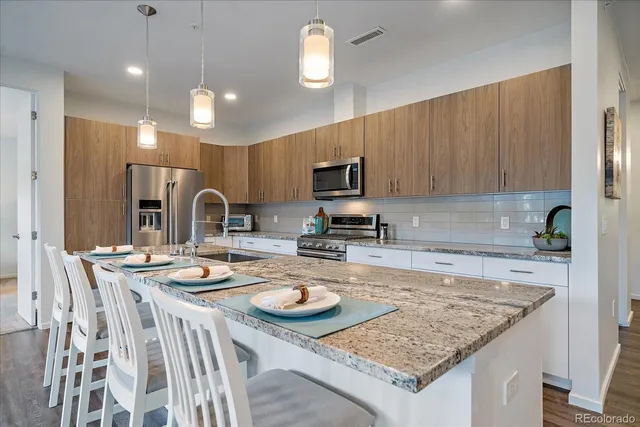 a large kitchen with stainless steel appliances lots of counter space and a sink