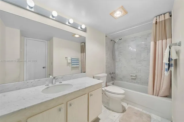 a bathroom with a granite countertop sink a toilet and shower