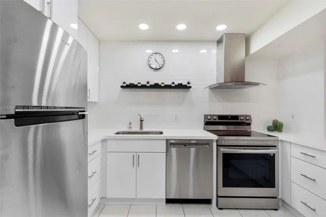 a kitchen with stainless steel appliances a stove a sink and a refrigerator