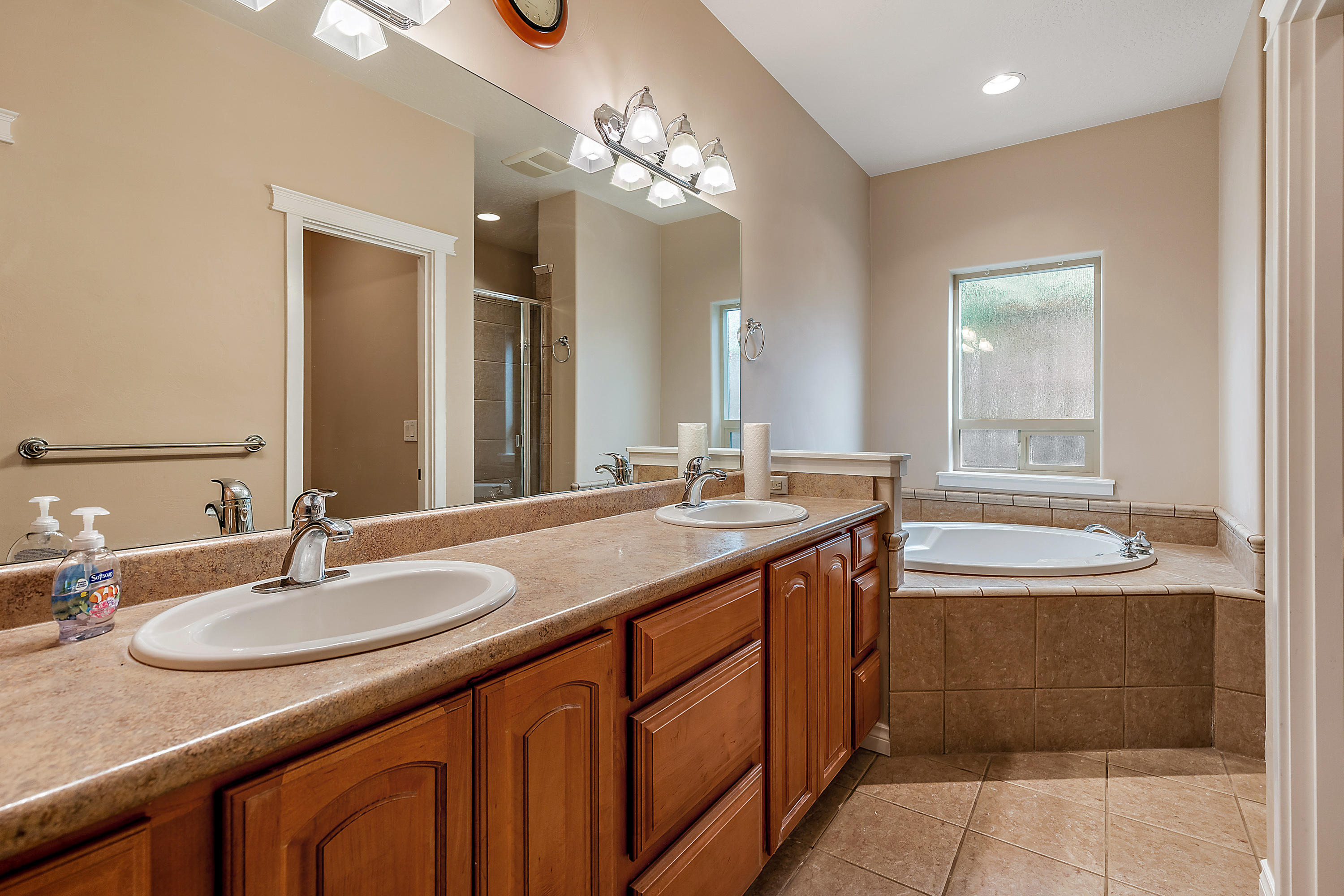 948 Win Way Eagle Point, OR 97524 - Photo 20 of 32 a bathroom with a granite countertop sink a large mirror and a bathtub