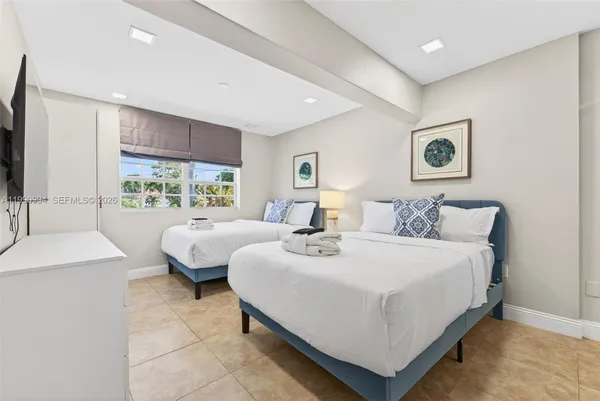 a large bedroom with a bed and large windows