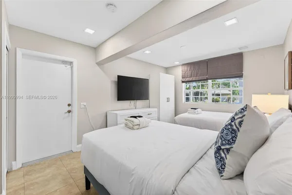 a bedroom with a bed and a flat screen tv