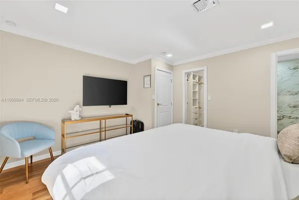 a bedroom with a bed and a flat screen tv