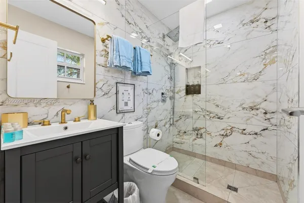 a bathroom with a sink toilet vanity and shower