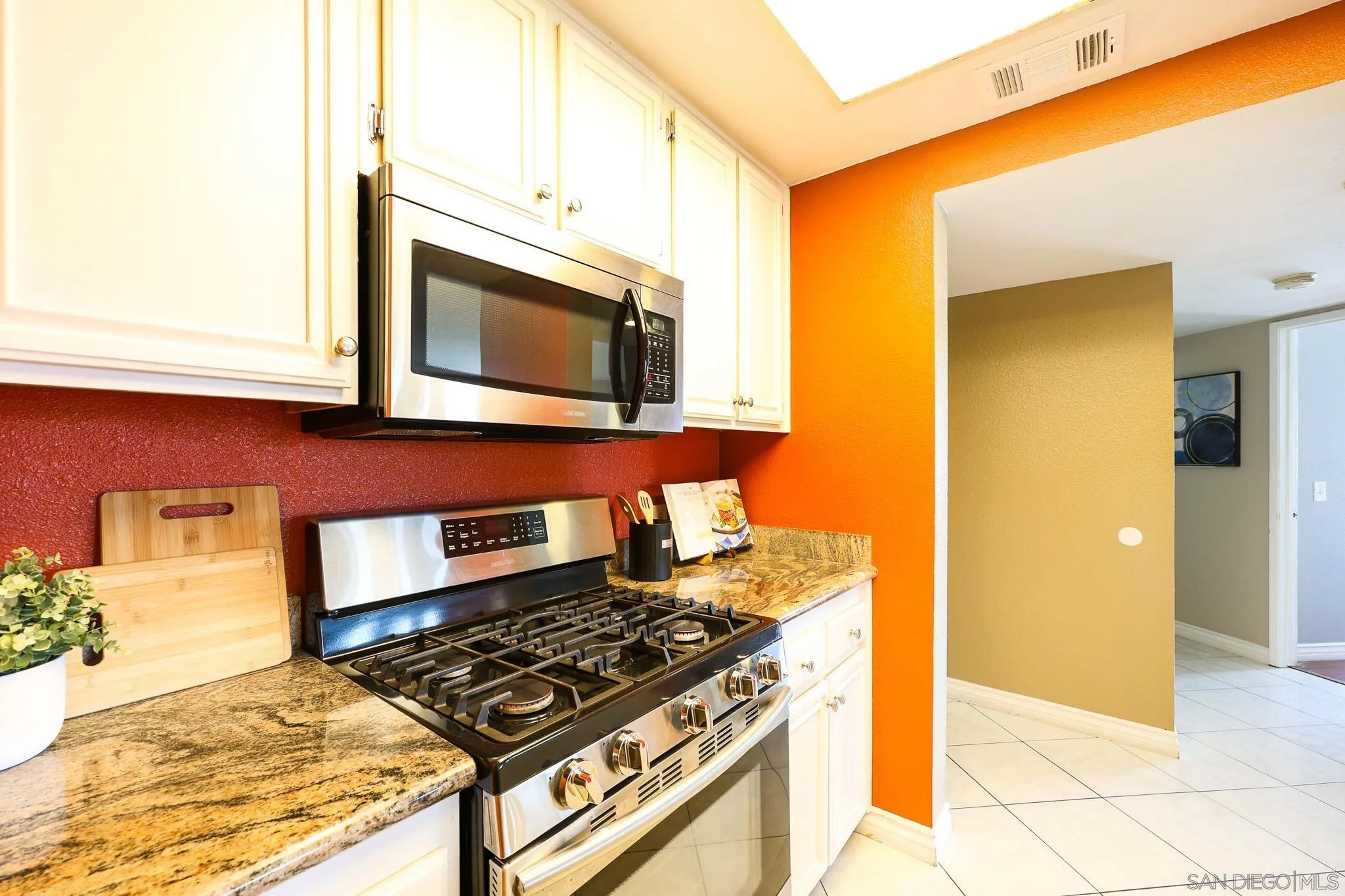2946 Anawood Way Spring Valley, CA 91978 - Photo 19 of 45 a kitchen with stainless steel appliances granite countertop a stove and a microwave