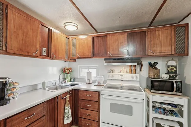 a kitchen with stainless steel appliances granite countertop a sink a stove and cabinets