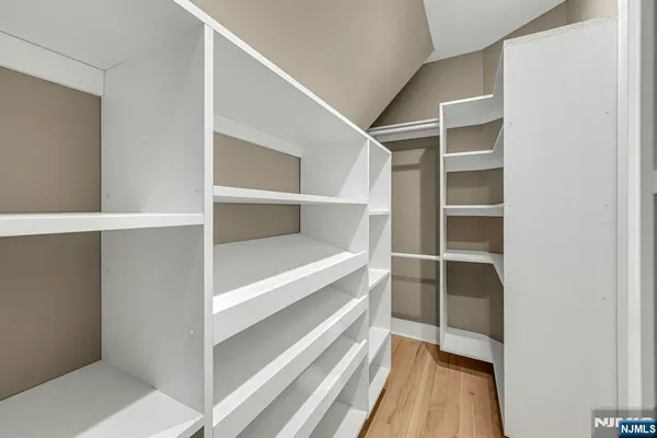 a view of walk in closet with empty racks